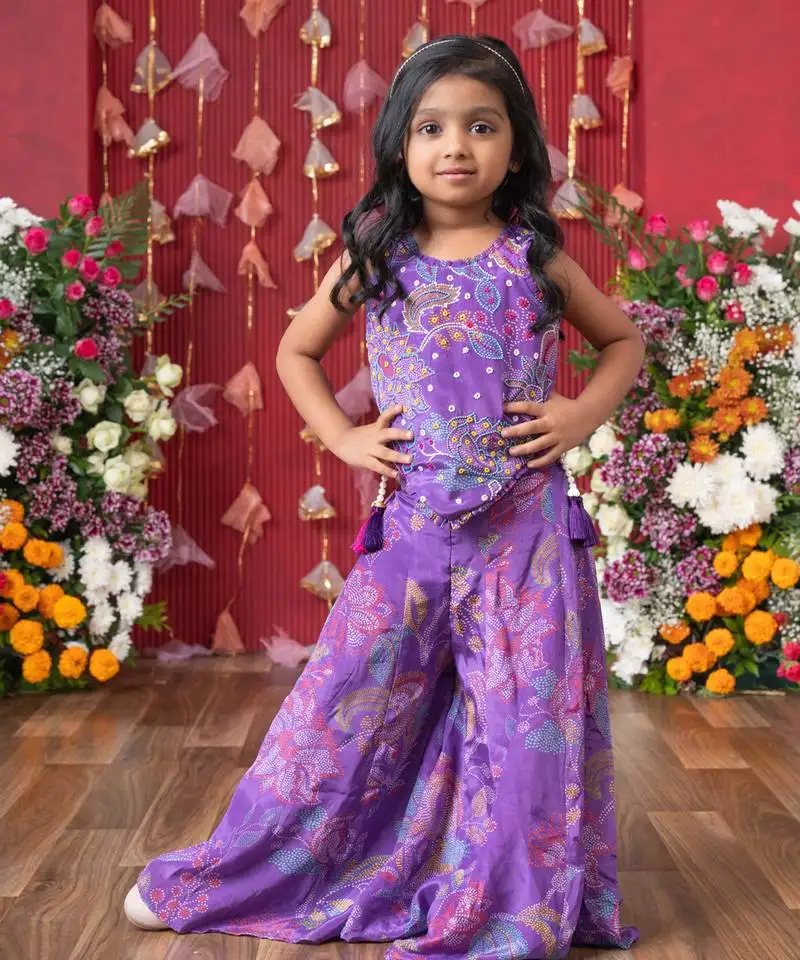 Add a pop of color to your celebrations with this vibrant purple printed top and flared palazzo set