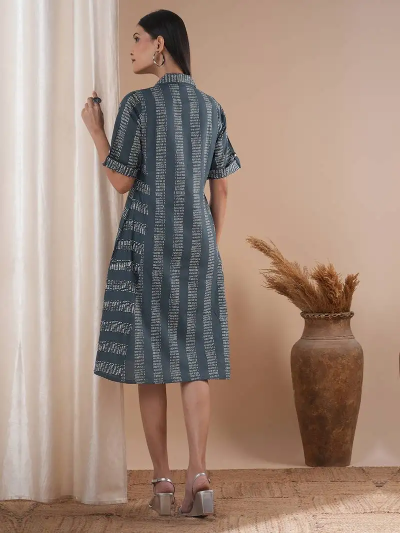 A collared printed dress with stripe manipulation panels, dual pockets and half sleeves with cuff.